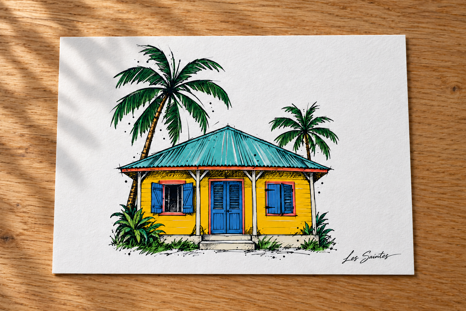 Carte postale — Kaz créole, papier texturé posé sur une table avec une légère ombre de feuillage — Atelier Karaïbes, Les Saintes