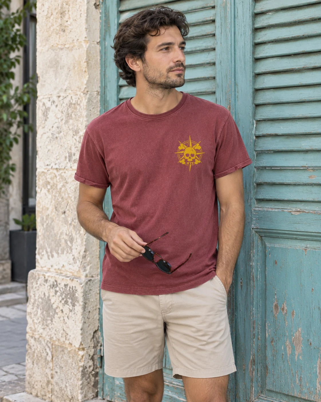 T-shirt vieilli homme rouge grenat délavé avec une boussole pirate 971 ornée d’un crâne imprimé en jaune moutarde, porté sur un ponton de voiliers aux Saintes à l’heure dorée