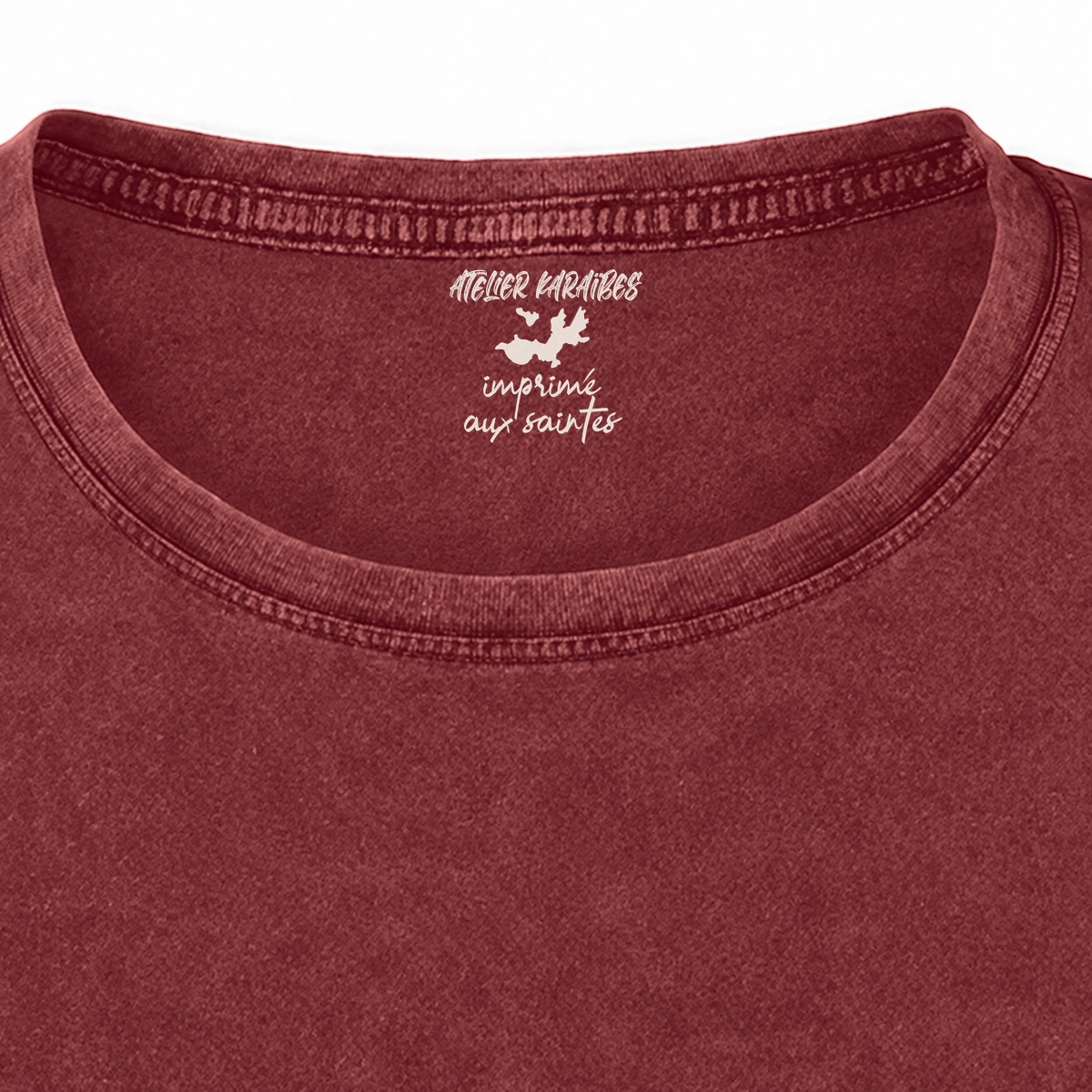 Gros plan de la signature intérieure Atelier Karaïbes imprimée en blanc sous le col du T-shirt vieilli femme rouge grenat délavé