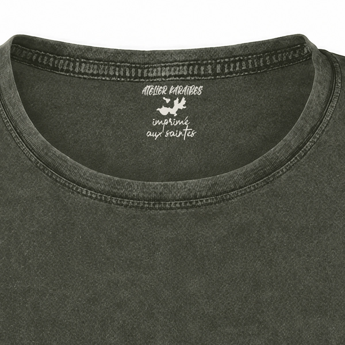 Gros plan de la signature intérieure Atelier Karaïbes imprimée en blanc sous le col du T-shirt vieilli femme vert militaire foncé délavé