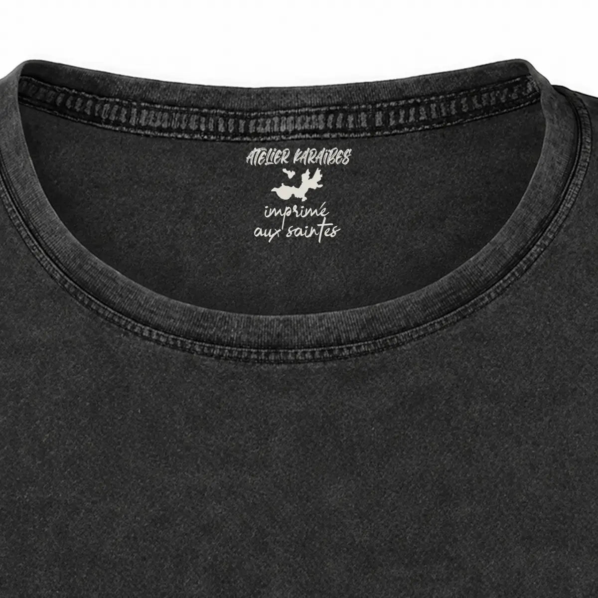 Gros plan de la signature intérieure Atelier Karaïbes imprimée en blanc sous le col du T-shirt vieilli femme gris anthracite délavé